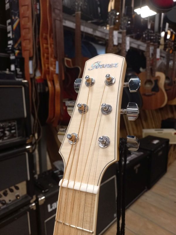 Prednja strana glave Ibanez AAM370E-OAW akustične ozvučene gitare sa vidljivim natpisom Ibanez, fotografisana u prodavnici Mix Music Company